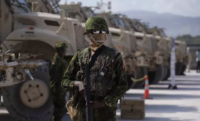 A Kenyan police officer part of a UN-backed multinational force stands next to a row of armored vehicles at their base during a visit by U.S. Ambassador to the United Nations Linda Thomas-Greenfield, in Port-au-Prince, Haiti, Monday, July 22, 2024. (Roberto Schmidt/Pool Photo via AP