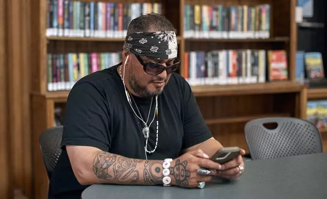 Jorge Morales, 54, spends time at a library during a hot day, Friday, June 21, 2024, in the Bronx Borough of New York. Tens of millions of Americans are facing major heat waves, with temperatures consistently exceeding 90 degrees (32 degrees Celsius).(AP Photo/Andres Kudacki)