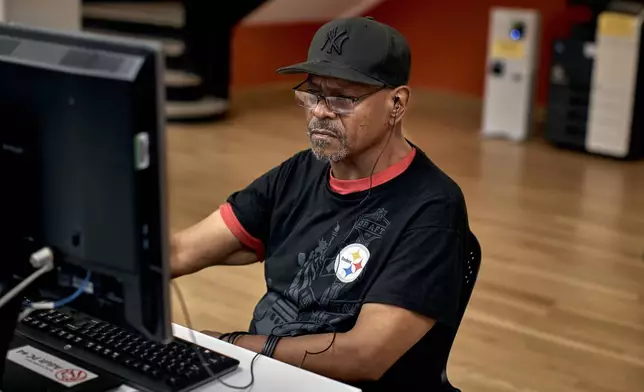 Howard Shillingford, 58, uses the computer as he spends time at a library during a hot day, Friday, June 21, 2024, in the Bronx Borough of New York. Tens of millions of Americans are facing major heat waves, with temperatures consistently exceeding 90 degrees (32 degrees Celsius). (AP Photo/Andres Kudacki)