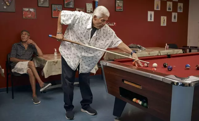 Luis Vazquez, 78, center plays pool with Pedro Navarez, 67, left, at a cooling center during a hot day, Friday, June 21, 2024, in the Bronx Borough of New York. The heat isn’t just uncomfortable. It’s the top cause of weather-related fatalities nationwide, quietly killing an average of 350 New Yorkers each year, according to a city mortality report.(AP Photo/Andres Kudacki)