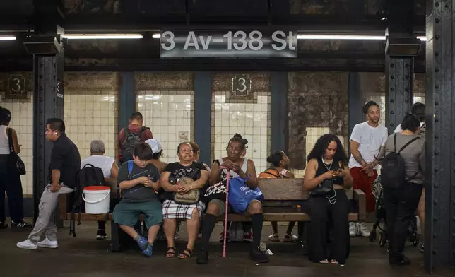 People wait for the train on a hot day, Friday, June 21, 2024, in the Bronx Borough of New York. Tens of millions of Americans are facing major heat waves, with temperatures consistently exceeding 90 degrees (32 degrees Celsius). (AP Photo/Andres Kudacki)