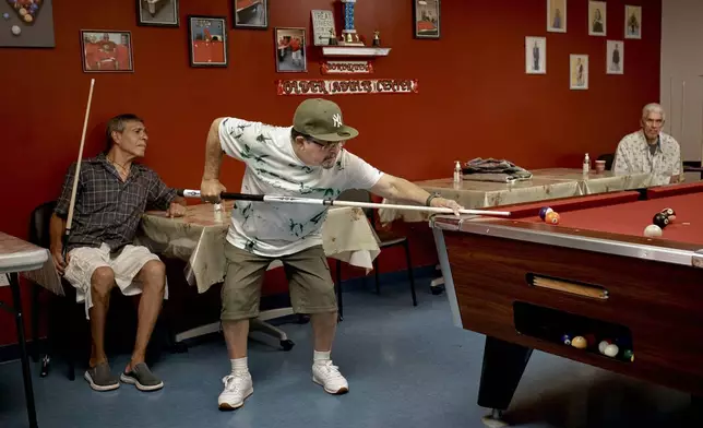 Elderly men play pool at a cooling center during a hot day, Friday, June 21, 2024, in the Bronx Borough of New York. The heat isn’t just uncomfortable. It’s the top cause of weather-related fatalities nationwide, quietly killing an average of 350 New Yorkers each year, according to a city mortality report.(AP Photo/Andres Kudacki)