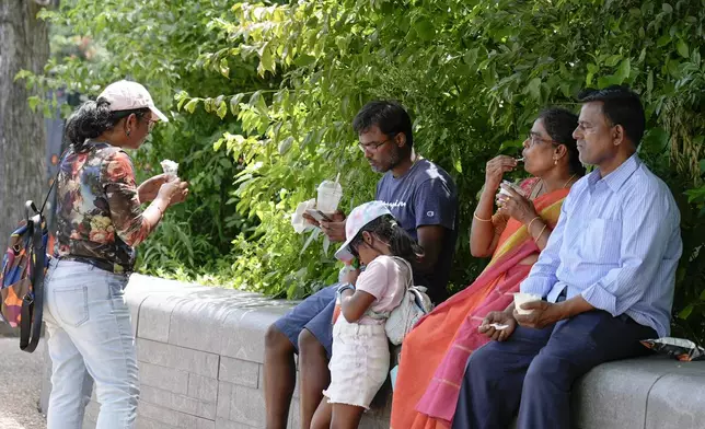 Radha Ramya, second from right, eats her ice cream with family members Nadamuni Ramya, from left, Dinakar Ramya, Nirvi Ramya and Devineni Ramya at the National Mall near the U.S. Capitol, Friday, July 5, 2024, in Washington. (AP Photo/Mariam Zuhaib)