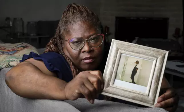 Janet Jarrett holds a photograph of her, Pamela Jarrett, at the home they shared Friday, July 19, 2024, in Spring, Texas. Pamela Jarrett passed away after suffering heat related distress due to the power outage caused by hurricane Beryl. (AP Photo/Michael Wyke)