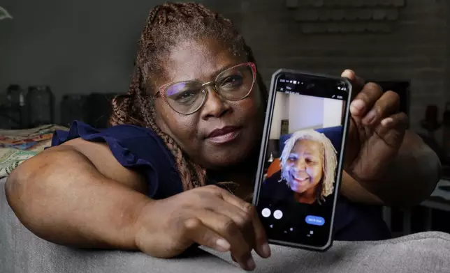 Janet Jarrett shows a photo of her sister, Pamela Jarrett, she keeps on her phone at the home they shared Friday, July 19, 2024, in Spring, Texas. Pamela Jarrett passed away after suffering heat related distress due to the power outage caused by hurricane Beryl. (AP Photo/Michael Wyke)