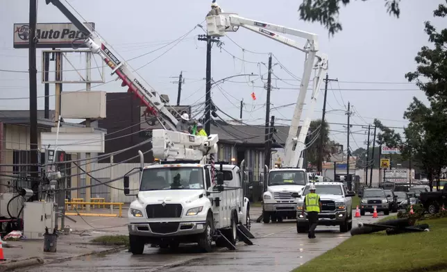 FILE - Utility crews work to restore electricity in Houston, Thursday, July 11, 2024. As of Thursday, July 18, most Houston residents finally had electricity after more than a week of widespread outages. (AP Photo/Lekan Oyekanmi, File)