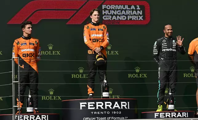 McLaren driver Oscar Piastri of Australia, celebrates on the podium with second placed McLaren driver Lando Norris of Britain, left, and third Mercedes driver Lewis Hamilton of Britain after the Hungarian Formula One Grand Prix race at the Hungaroring racetrack in Mogyorod, Hungary, Sunday, July 21, 2024. (AP Photo/Denes Erdos)