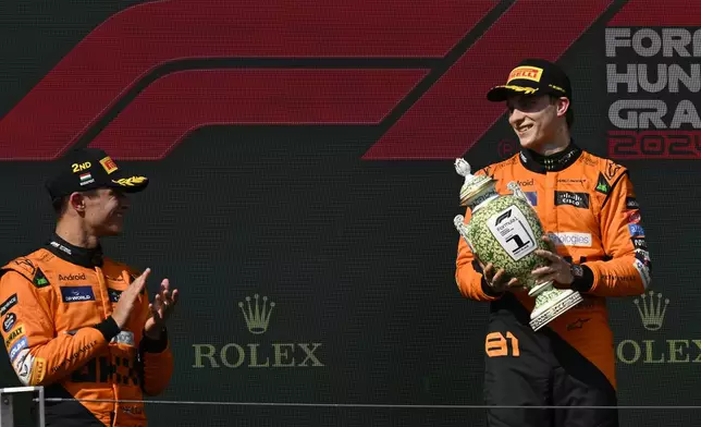 McLaren driver Oscar Piastri of Australia, celebrates on the podium with second placed McLaren driver Lando Norris of Britain, left, and third Mercedes driver Lewis Hamilton of Britain after the Hungarian Formula One Grand Prix race at the Hungaroring racetrack in Mogyorod, Hungary, Sunday, July 21, 2024. (AP Photo/Denes Erdos)