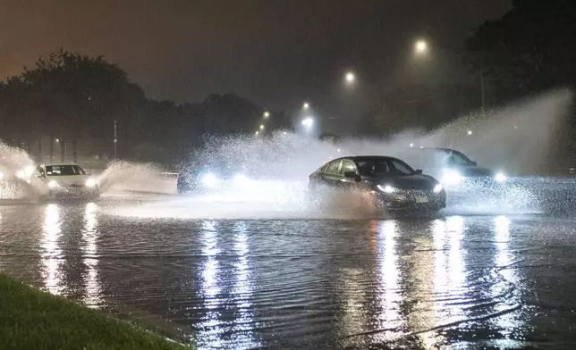 Vehicles make their way through a flooded section of DuSable Lake Shore Drive after a second severe storm raged through Chicago, Monday, July 15, 2024. (Tyler Pasciak LaRiviere/Chicago Sun-Times via AP)