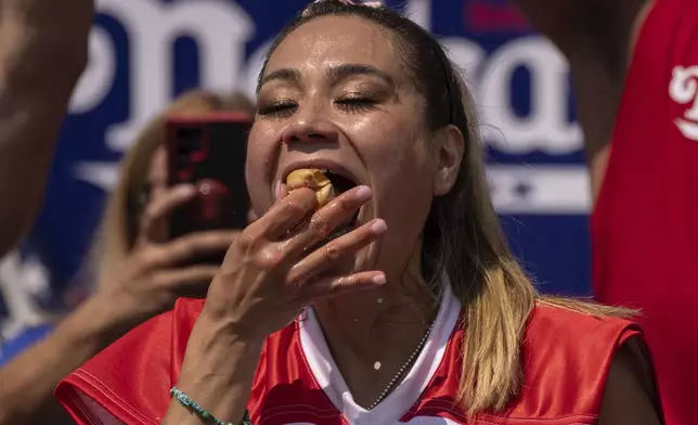 FILE - Competitive eater Miki Sudo eats a hot dog during the 2023 Nathan's Famous Fourth of July hot dog eating contest in the Coney Island section of the Brooklyn borough of New York, July 4, 2023. The annual Nathan’s Famous Fourth of July hot dog eating contest will see a slate of competitive eaters wolf down as many franks as they can in New York City on Thursday, July 4, 2024. (AP Photo/Yuki Iwamura, File)