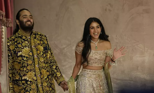 FILE - Anant Ambani, left, and Radhika Merchant pose for photographers during their pre-wedding ceremony in Mumbai, India, Friday, July 5, 2024. (AP Photo/Rajanish Kakade, File)