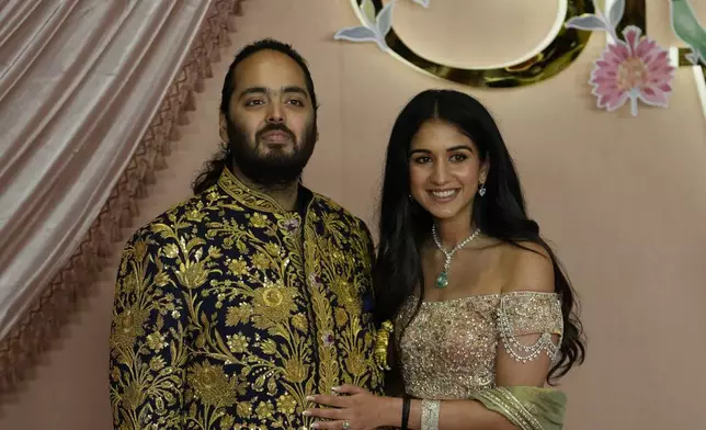 FILE - Anant Ambani, left, and Radhika Merchant pose for photographers during their pre-wedding ceremony in Mumbai, India, Friday, July 5, 2024. (AP Photo/Rajanish Kakade, File)