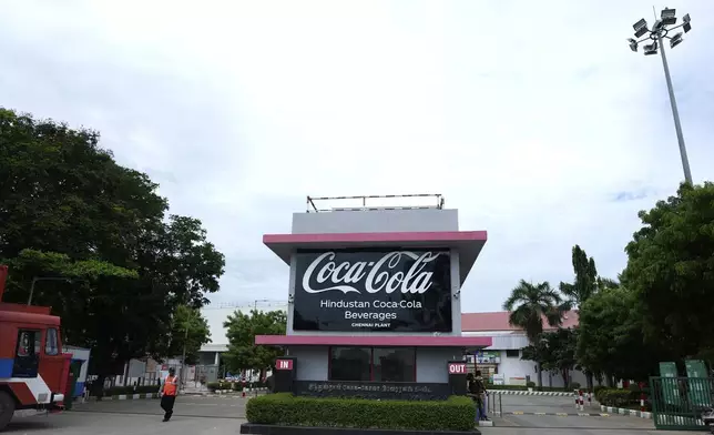 Security staff stand in front of the Hindustan Coca-Cola Beverages factory in Thiruvallur district, on the outskirts of Chennai, India, Tuesday, July 16, 2024. (AP Photo/Mahesh Kumar A.)