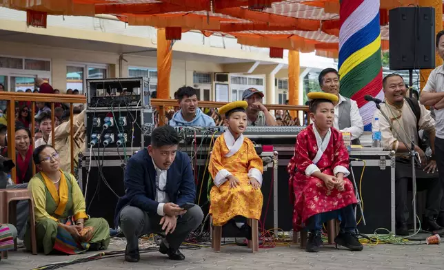 Two boys in a traditional costumes wait for their turn to perform a traditional dance at an event to celebrate the 89th birthday of Tibetan spiritual leader the Dalai Lama at the Tsuglakhang temple in Dharamshala, India, Saturday, July 6, 2024. (AP Photo/Ashwini Bhatia)