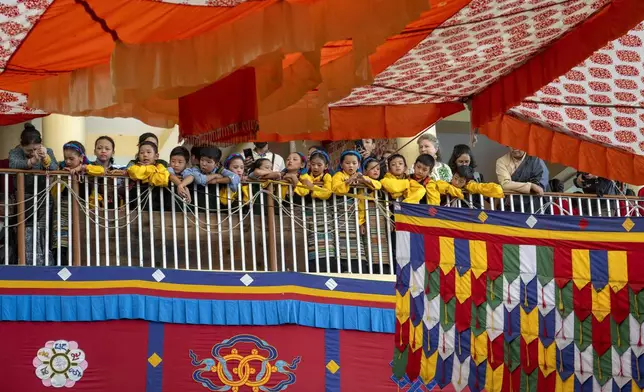 Exiled Tibetan children in ceremonial outfits look on from a balcony as they wait to perform a traditional dance at an event to celebrate the 89th birthday of Tibetan spiritual leader the Dalai Lama at the Tsuglakhang temple in Dharamshala, India, Saturday, July 6, 2024. (AP Photo/Ashwini Bhatia)