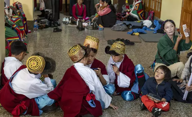 Exiled Tibetan children in ceremonial outfits wait to perform a traditional dance at an event to celebrate the 89th birthday of Tibetan spiritual leader the Dalai Lama at the Tsuglakhang temple in Dharamshala, India, Saturday, July 6, 2024. (AP Photo/Ashwini Bhatia)