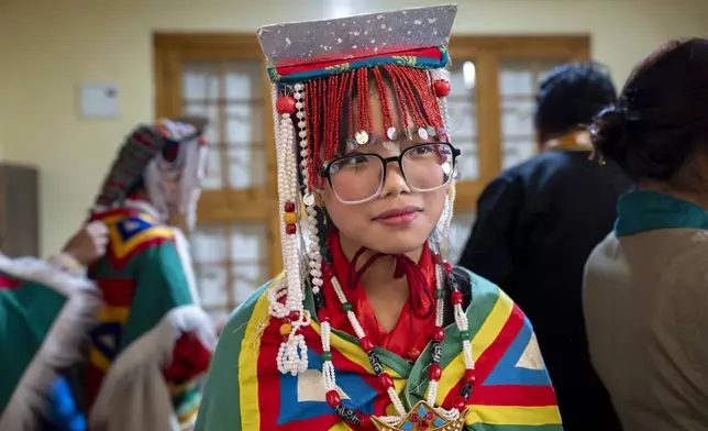 Tsering Dolma, a school girl, gets ready to perform a traditional dance at an event to celebrate the 89th birthday of Tibetan spiritual leader the Dalai Lama at the Tsuglakhang temple in Dharamshala, India, Saturday, July 6, 2024. (AP Photo/Ashwini Bhatia)