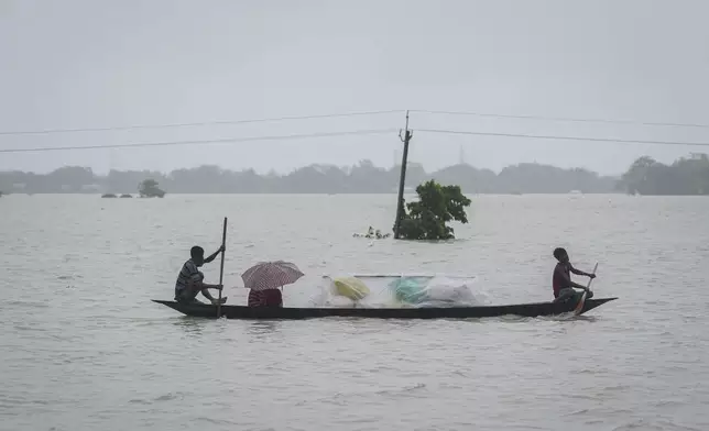 Flood affected people travel with their belongings through flood waters in Sildubi village in Morigaon district in the northeastern state of Assam, India, Tuesday, July 2, 2024. Floods and landslides triggered by heavy rains have killed more than a dozen people over the last two weeks in India's northeast. (AP photo/Anupam Nath)