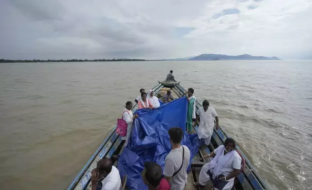 Health officers hold up a tarpaulin to cover 25-year-old Jahanara Khatoon as she delivers a baby on a boat over the River Brahmaputra, in the northeastern Indian state of Assam, Wednesday, July 3, 2024. (AP Photo/Anupam Nath)