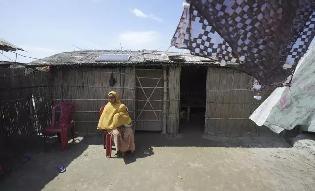25-year-old Jahanara Khatoon, who is at full-term pregnancy, sits holding her younger son outside their home in Sandoh Khaiti Char, in the northeastern Indian state of Assam, Wednesday, July 3, 2024. (AP Photo/Anupam Nath)