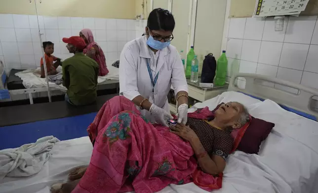 A woman injured in a stampede receives treatment at Hathras district hospital, Uttar Pradesh, India, Wednesday, July 3, 2024. Thousands of people at a religious gathering rushed to leave a makeshift tent, setting off a stampede Tuesday that killed more than hundred people and injured scores. (AP Photo/Rajesh Kumar Singh)