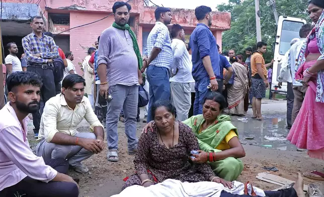 Women mourn next to the body of a relative outside the Sikandrarao hospital in Hathras district about 350 kilometers (217 miles) southwest of Lucknow, India, Tuesday, July 2, 2024. At least 60 people are dead and scores are injured after a stampede at a religious gathering of thousands of people in northern India, officials said Tuesday.(AP Photo/Manoj Aligadi)