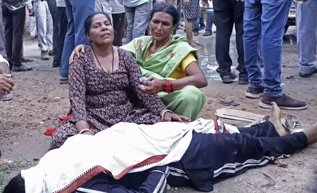 Women mourn next to the body of a relative outside the Sikandrarao hospital in Hathras district about 350 kilometers (217 miles) southwest of Lucknow, India, Tuesday, July 2, 2024. At least 60 people are dead and scores are injured after a stampede at a religious gathering of thousands of people in northern India, officials said Tuesday.(AP Photo/Manoj Aligadi)