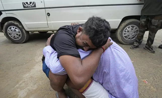 A man weeps while hugging the father-in-law of his 37-year-old sister Ruby, victim of a stampede, outside Hathras district hospital, Uttar Pradesh, India, Wednesday, July 3, 2024. Thousands of people at a religious gathering rushed to leave a makeshift tent, setting off a stampede Tuesday that killed more than hundred people and injured scores. (AP Photo/Rajesh Kumar Singh)