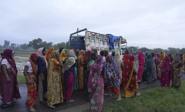 Family members and neighbors grieve near the body of Savitri Devi, 50, who died during a stampede, in Ramnagar, in the northern Indian state of Uttar Pradesh, Wednesday, July 3, 2024. Devi was among more than 120 people who died in a stampede last week at a religious festival in northern India, as the faithful surged toward the preacher and chaos ensued among the attendees. (AP Photo/Rajesh Kumar Singh)