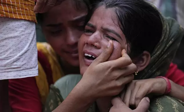 Sonam weeps as the final rites are performed for her mother Savitri Devi, 50, who died during a stampede, in Ramnagar, in the northern Indian state of Uttar Pradesh, Wednesday, July 3, 2024. Devi was among more than 120 people who died in a stampede last week at a religious festival in northern India, as the faithful surged toward the preacher and chaos ensued among the attendees. (AP Photo/Rajesh Kumar Singh)