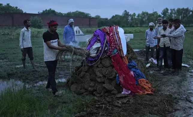 Ajay Kumar lights the funeral pyre of his mother Savitri Devi, 50, who died during a stampede, in Ramnagar, in the northern Indian state of Uttar Pradesh, Wednesday, July 3, 2024. "My parents believed that Babaji would lift all our burdens," Kumar said, while adding that he also went to religious gatherings of the Baba because it became a family tradition. (AP Photo/Rajesh Kumar Singh)