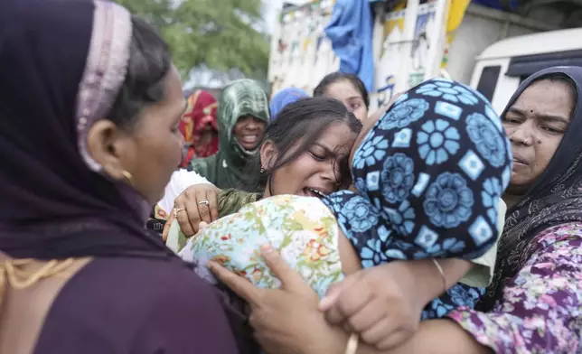 Sonam is consoled by relatives after the body of her mother Savitri Devi, 50, who died during a stampede, is brought home for cremation in Ramnagar, in the northern Indian state of Uttar Pradesh, Wednesday, July 3, 2024. Devi was among more than 120 people who died in a stampede last week at a religious festival in northern India, as the faithful surged toward the preacher and chaos ensued among the attendees. (AP Photo/Rajesh Kumar Singh)