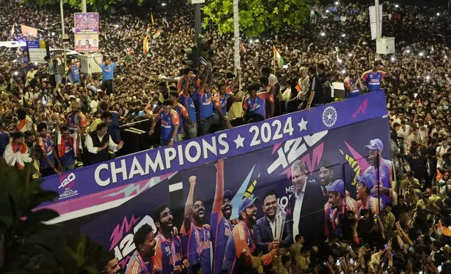 Crowds surround a double-decker bus as the India cricket team takes part in a parade celebrating their T20 Cricket World Cup win, Thursday, July 4, 2024, near Wankhede Stadium along Marin Drive in Mumbai, India. (AP Photo/Rajanish Kakade)