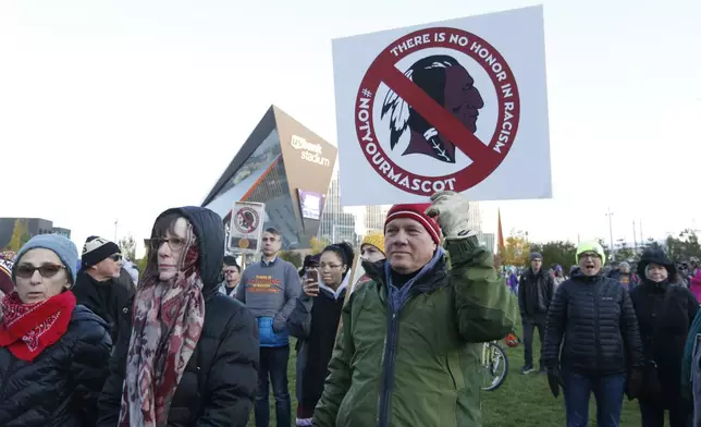 FILE - In this Oct. 24, 2019, file photo, Native American leaders protest against the Redskins team name and logo outside U.S. Bank Stadium before an NFL football game between the Minnesota Vikings and the Washington Redskins in Minneapolis. Many Native Americans thought a bitter debate over the U.S. capital's football mascot was over when the team became the Washington Commanders. The organization left behind its name, a racist slur dating to the founding of the United States. The original logo was designed by a member of the Blackfeet Nation. Now a white Republican U.S. senator from Montana is reviving the debate by blocking a bill funding the revitalization of the team's stadium unless the NFL and the Commanders bring back the former logo in some form. (AP Photo/Bruce Kluckhohn, File)