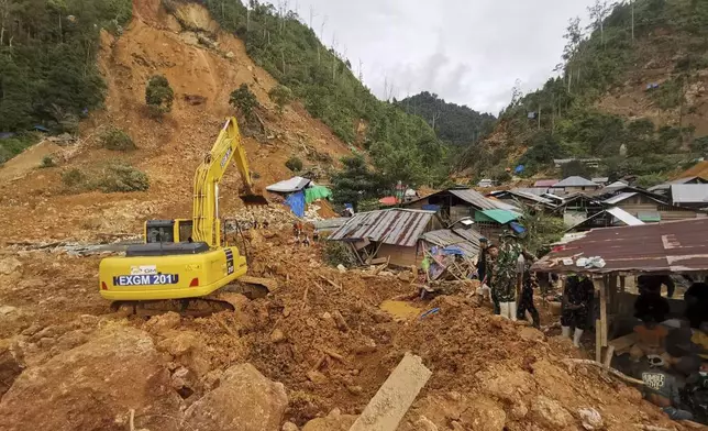 In this photo released by the Indonesian National Search and Rescue Agency (BASARNAS), rescuers search for victims at the site of a landslide in Suwawa on Sulawesi Island, Indonesia, Wednesday, July 10, 2024. Search efforts for those trapped in a deadly landslide intensified Wednesday, with more rescuers deployed to search an unauthorized gold mine on Indonesia's Sulawesi island that saw a number of deaths over the weekend. (BASARNAS via AP)