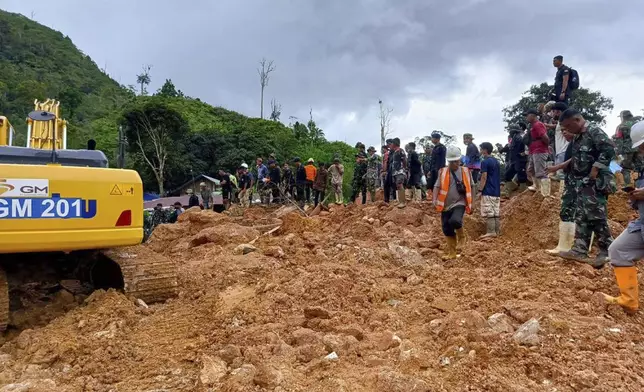 In this photo released by the Indonesian National Search and Rescue Agency (BASARNAS), rescuers search for victims at the site of a landslide in Suwawa on Sulawesi Island, Indonesia, Wednesday, July 10, 2024. Search efforts for those trapped in a deadly landslide intensified Wednesday, with more rescuers deployed to search an unauthorized gold mine on Indonesia's Sulawesi island that saw a number of deaths over the weekend. (BASARNAS via AP)