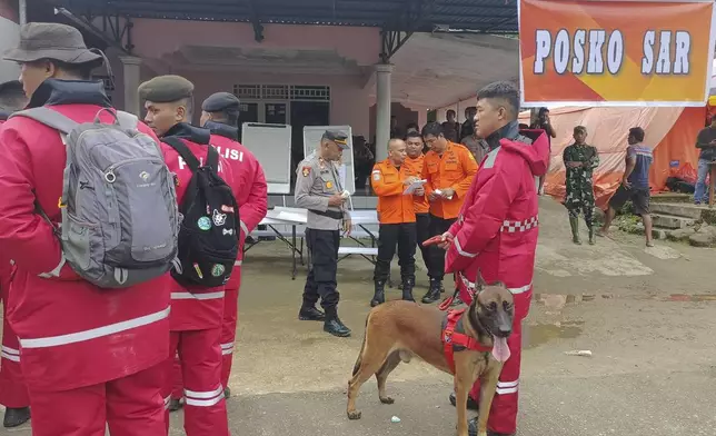 In this photo released by the Indonesian National Search and Rescue Agency (BASARNAS), rescuers prepare to head out to the site of a landslide that killed a number of people, in Suwawa on Sulawesi Island, Indonesia, Monday, July 8, 2024. The landslide triggered by torrential rains crashed onto an unauthorized gold mining operation on Indonesia's Sulawesi island, killing a number of miners, officials said Monday. (BASARNAS via AP)
