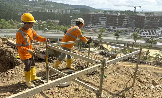 Workers are seen at a construction site in the new capital city in Penajam Paser Utara, East Kalimantan, Indonesia, Monday, July 29, 2024. Widodo started work Monday from the new presidential palace in his country's ambitious new capital Nusantara, where he intends to spend the last few months of his presidency. (AP Photo/ Fadlan Syam)