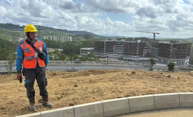 A worker stands near a construction site in the new capital city in Penajam Paser Utara, East Kalimantan, Indonesia, Monday, July 29, 2024. Widodo started work Monday from the new presidential palace in his country's ambitious new capital Nusantara, where he intends to spend the last few months of his presidency. (AP Photo/ Fadlan Syam)