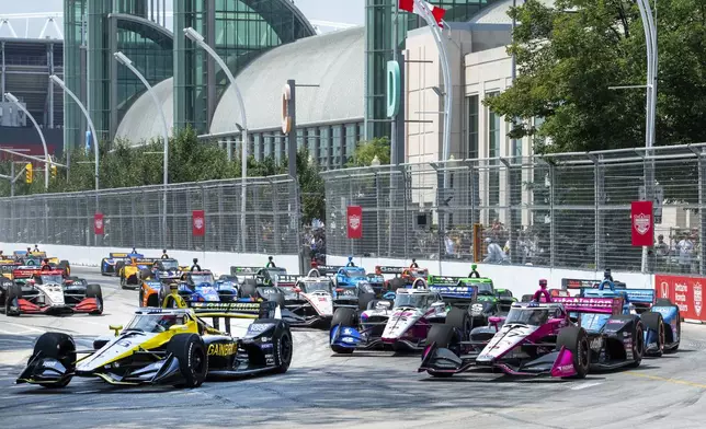 Colton Herta (26), of the United States, leads the field into the first turn of an IndyCar auto race in Toronto, Sunday, July 21, 2024. (Frank Gunn/The Canadian Press via AP)