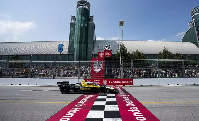 Colton Herta (26), of the United States, crosses the finish line to win an IndyCar auto race in Toronto, Sunday, July 21, 2024. (Arlyn McAdorey/The Canadian Press via AP)