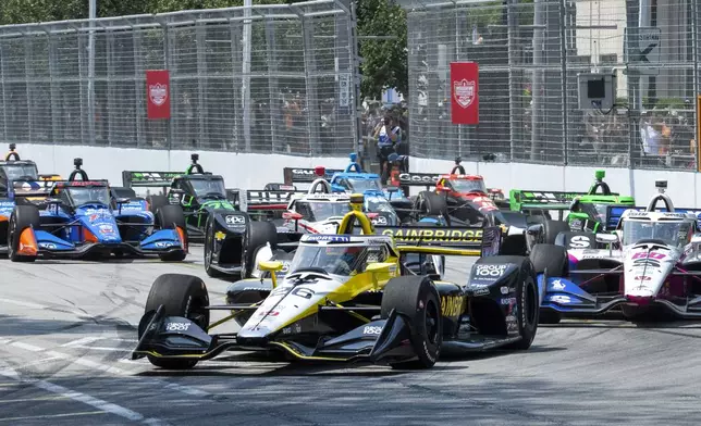 Colton Herta (26), of the United States, leads the field into the first turn of an IndyCar auto race in Toronto, Sunday, July 21, 2024. (Frank Gunn/The Canadian Press via AP)