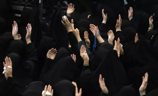 Iranian Shiite Muslim women pray during Ashoura mourning ritual, commemorating the 7th century martyrdom of Prophet Muhammad's grandson, Hussein, in the battle of Karbala in present-day Iraq, at the old main bazaar of Tehran, Iran, Tuesday, July 16, 2024. Shiites represent over 10% of the world's 1.8 billion Muslims and view Hussein as the rightful successor to the Prophet Muhammad. (AP Photo/Vahid Salemi)