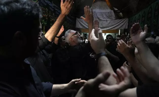 Iranian Shiite Muslims beat their chests during Ashoura mourning ritual, commemorating the 7th century martyrdom of Prophet Muhammad's grandson, Hussein, in the battle of Karbala in present-day Iraq, at the old main bazaar of Tehran, Iran, Tuesday, July 16, 2024. Shiites represent over 10% of the world's 1.8 billion Muslims and view Hussein as the rightful successor to the Prophet Muhammad. (AP Photo/Vahid Salemi)