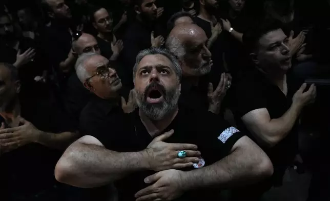 Iranian Shiite Muslims beat their chests during Ashoura mourning ritual, commemorating the 7th century martyrdom of Prophet Muhammad's grandson, Hussein, in the battle of Karbala in present-day Iraq, at the old main bazaar of Tehran, Iran, Tuesday, July 16, 2024. Shiites represent over 10% of the world's 1.8 billion Muslims and view Hussein as the rightful successor to the Prophet Muhammad. (AP Photo/Vahid Salemi)