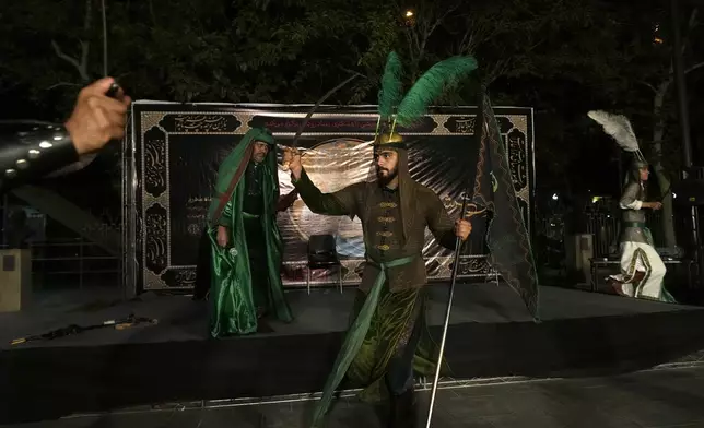 Actors play in a traditional theater, called Tazieh, re-enacting the 7th century Battle of Karbala in present-day Iraq, in which Shiites' Imam Hussein, the grandson of Prophet Muhammad and 72 of his companions, were killed, in downtown Tehran, Iran, Monday, July 15, 2024. Shiites across Iran mourn the martyrdom of their third Imam day ahead of Ashoura, when Hussein was tragically killed. (AP Photo/Vahid Salemi)