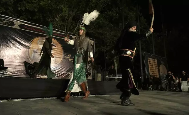 Iranian actors play in a traditional theatre, called Tazieh, re-enacting the 7th century Battle of Karbala in present-day Iraq, in which Shiites' Imam Hussein, the grandson of Prophet Muhammad and 72 of his companions, were killed, in downtown Tehran, Iran, Monday, July 15, 2024. Shiites across Iran mourn the martyrdom of their third Imam days ahead of Ashoura, when Hussein was tragically killed. (AP Photo/Vahid Salemi)