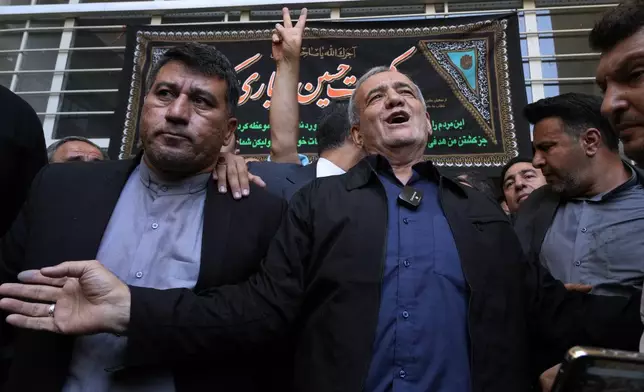 Reformist candidate for the Iran's presidential election Masoud Pezeshkian, right, leaves a polling station after casting his vote, in Shahr-e-Qods near Tehran, Iran, Friday, July 5, 2024. Iranians are voting in a runoff election to replace the late President Ebrahim Raisi, who was killed in a May helicopter crash in the country’s northwest along with the foreign minister and several other officials. (AP Photo/Vahid Salemi)