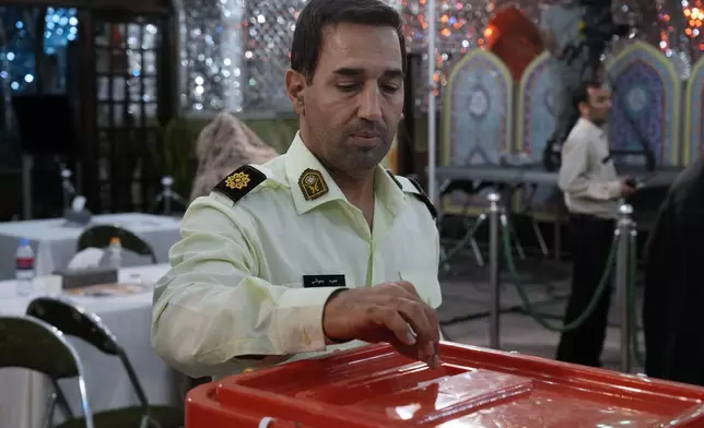 A policeman casts his vote for the presidential election in a polling station at the shrine of Saint Saleh in northern Tehran, Iran, Friday, July 5, 2024. Iran held a runoff presidential election on Friday that pitted a hard-line former nuclear negotiator against a reformist lawmaker. (AP Photo/Vahid Salemi)