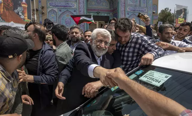 Candidate for the Iran's presidential election Saeed Jalili, a hard-line former nuclear negotiator, shakes hand with a supporter after casting his vote for the presidential runoff election in Qarchak near Tehran, Iran, Friday, July 5, 2024. Iran was holding a runoff presidential election Friday pitting a hard-line former nuclear negotiator against a reformist lawmaker, though both men earlier struggled to convince a skeptical public to cast ballots in the first round that saw the lowest turnout in the Islamic Republic's history. (AP Photo)